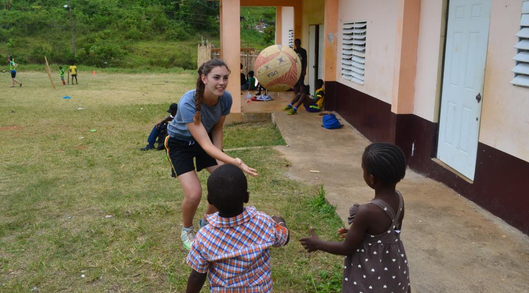 A Projects Abroad volunteer teaching kids hand-eye coordination A high school special volunteer teaching Jamaican kids hand-eye coordination with a ball